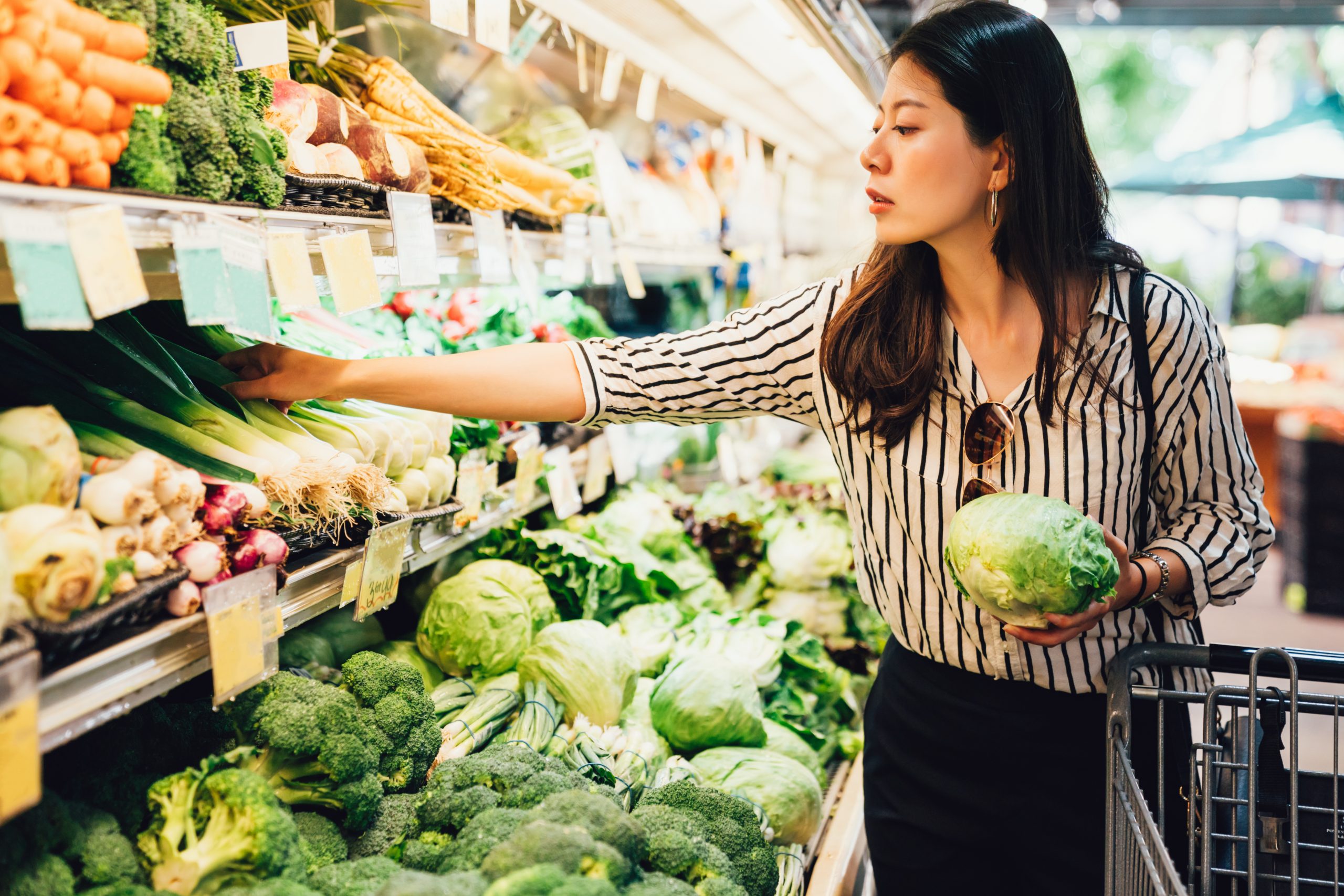Woman shopping for healthy vegetables at the grocery store