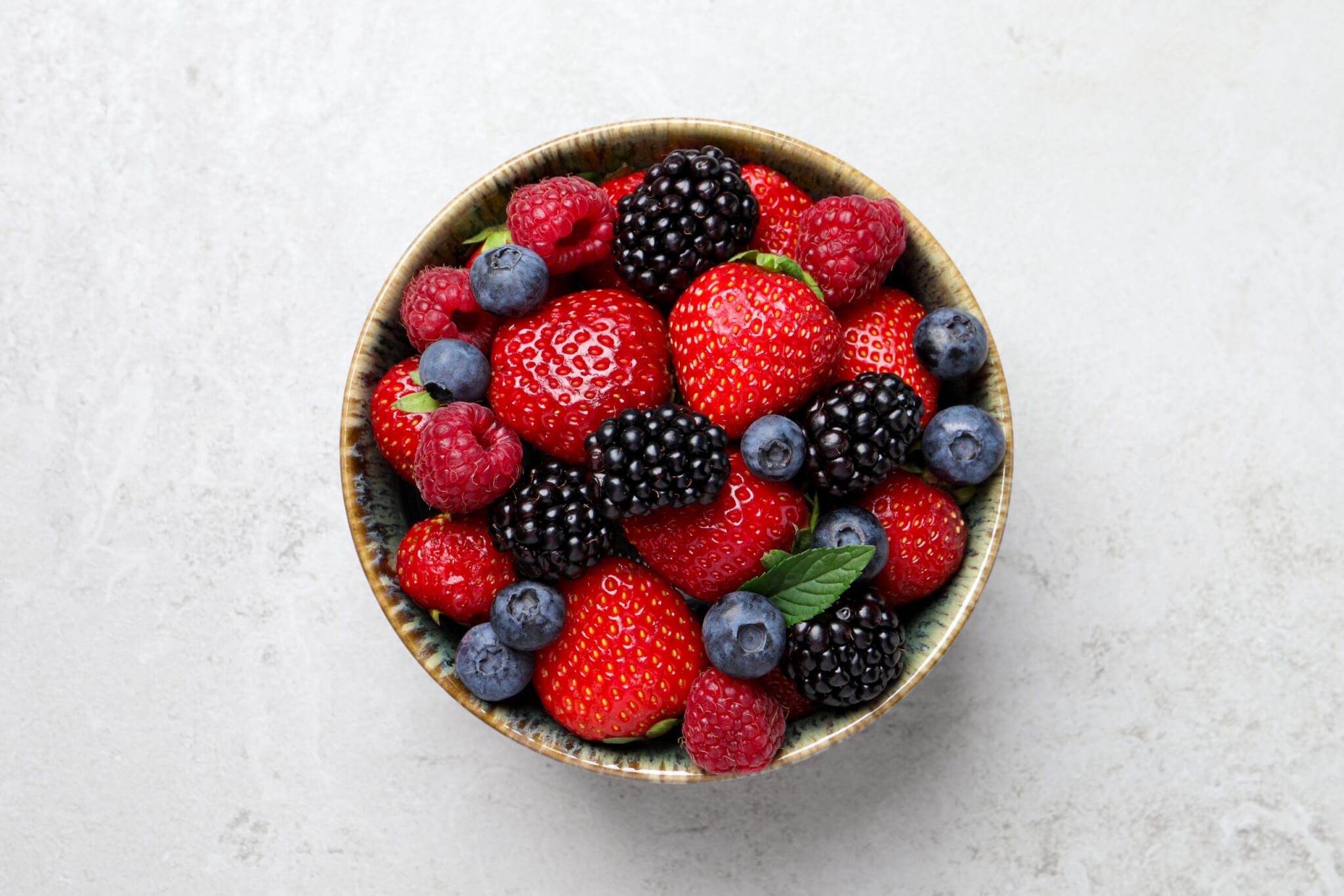 Bowl of healthy fresh blueberries, blackberries and strawberries