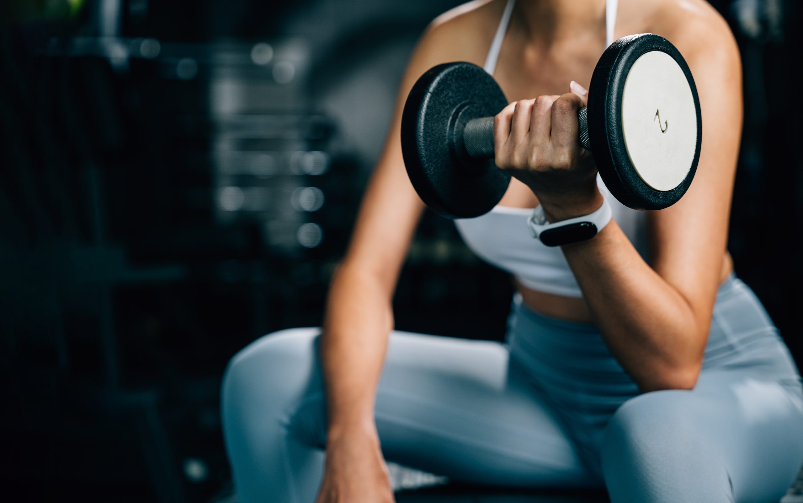 woman lifting weights at the gym for strength training